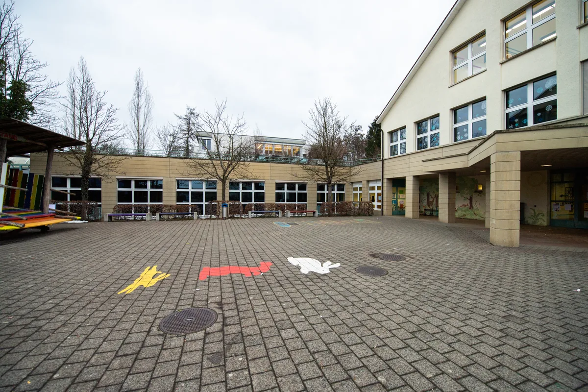 Das Schulhaus Hasenbühl erhält eine Photovoltaikanlage. Blick auf den Pausenplatz eines Schulhauses.